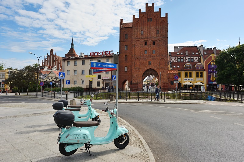 Widok na starówkę w Olsztynie, na pierwszym planie zaparkowane skutery